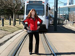 Accounting alumna, Heather McKillop, standing in front of RTD line