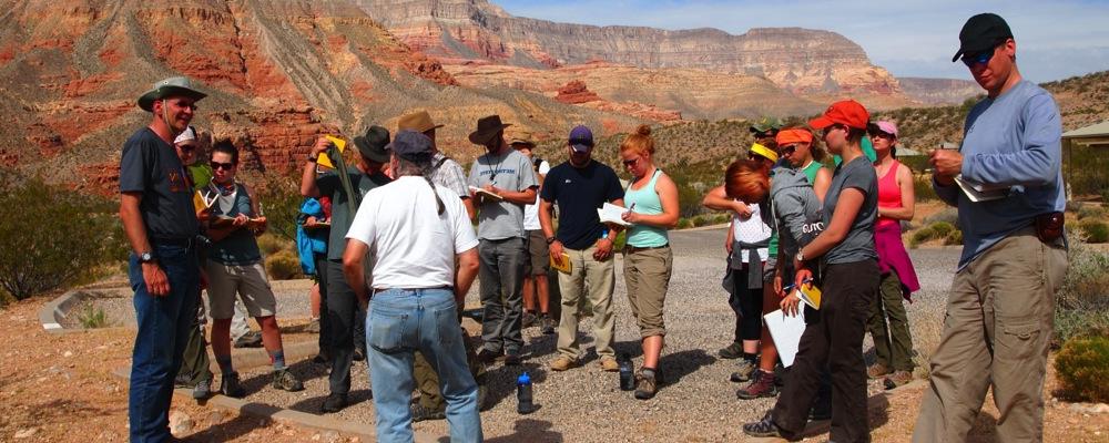 Geology Students listening to an instructor lecture with a mesa in the background