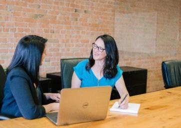 Two people sitting at a table talking to each other