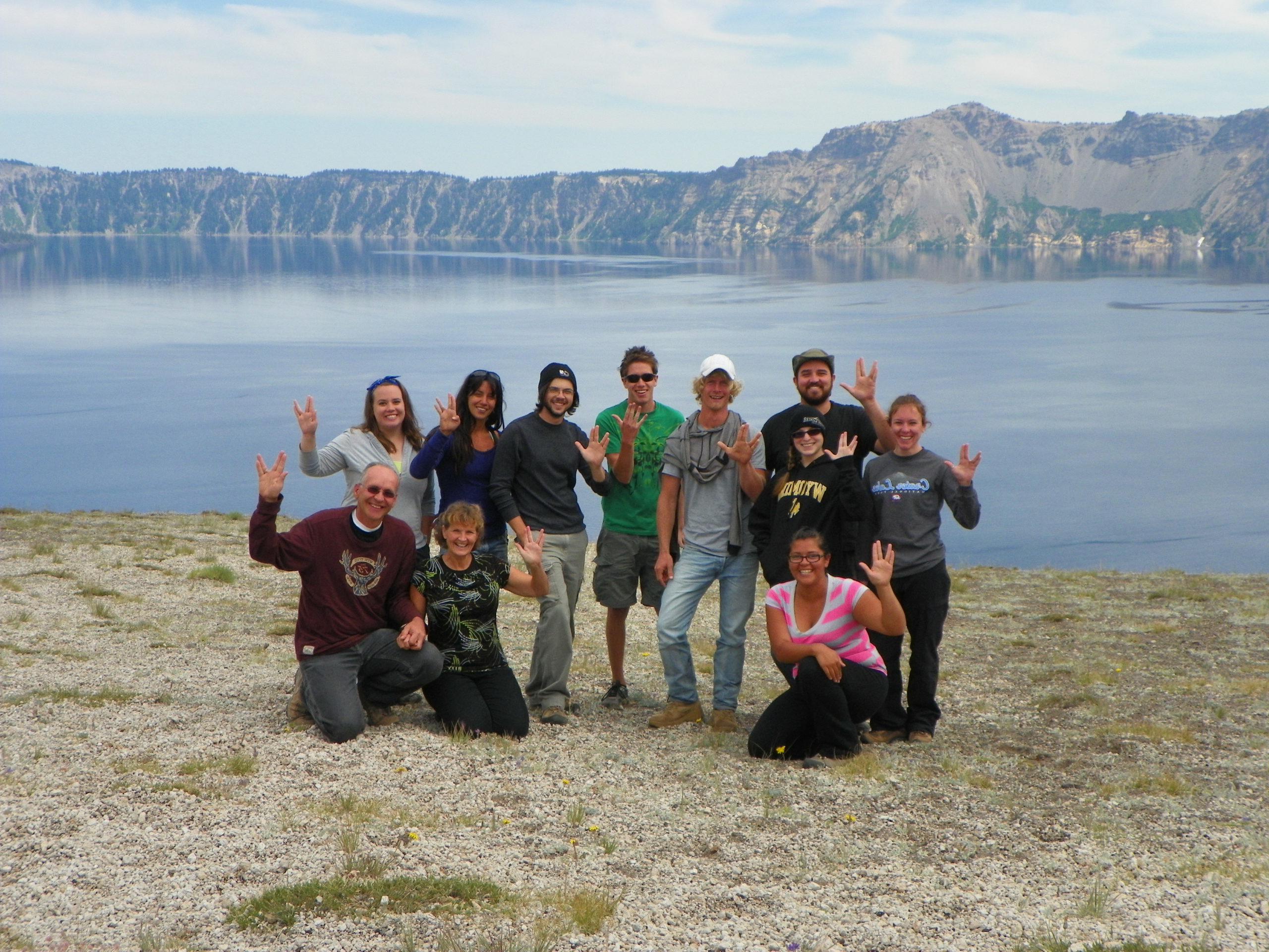 eleven people in front of a lake giving the vulcan salute